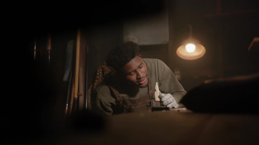 A young man is indoors and buildings something inside of his house