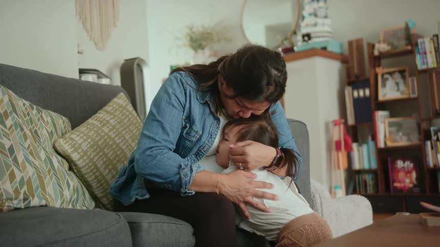 Pregnant mother and her baby daughter are hugging each other in the day time