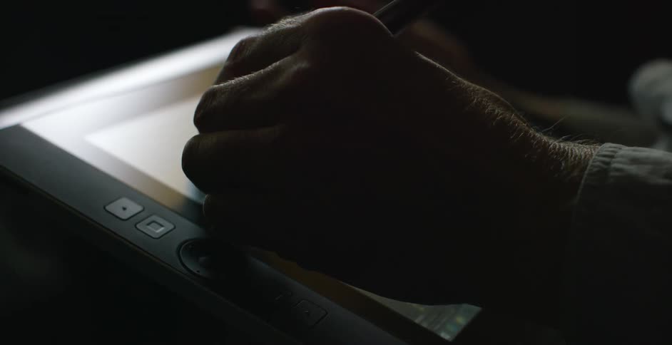 A man uses a tablet to edit a photo