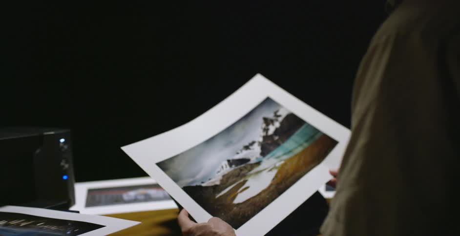 A man is printing photographs and examining them