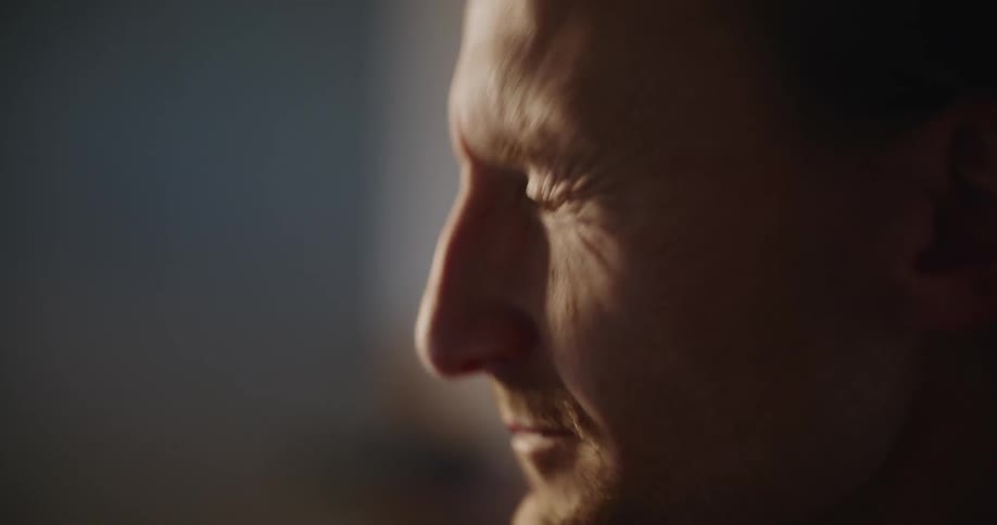 Man concentrating ahead rubs his eyes and blinks