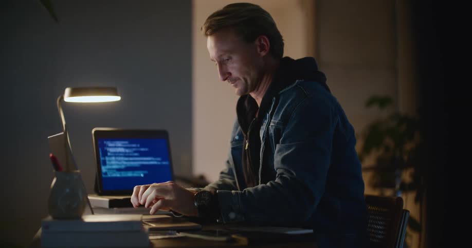 A man yawns as he uses the computer