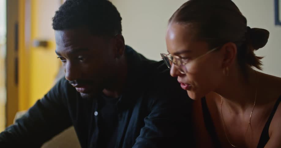 A man and woman talk and look at a laptop