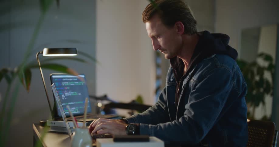A man types on his laptop at home