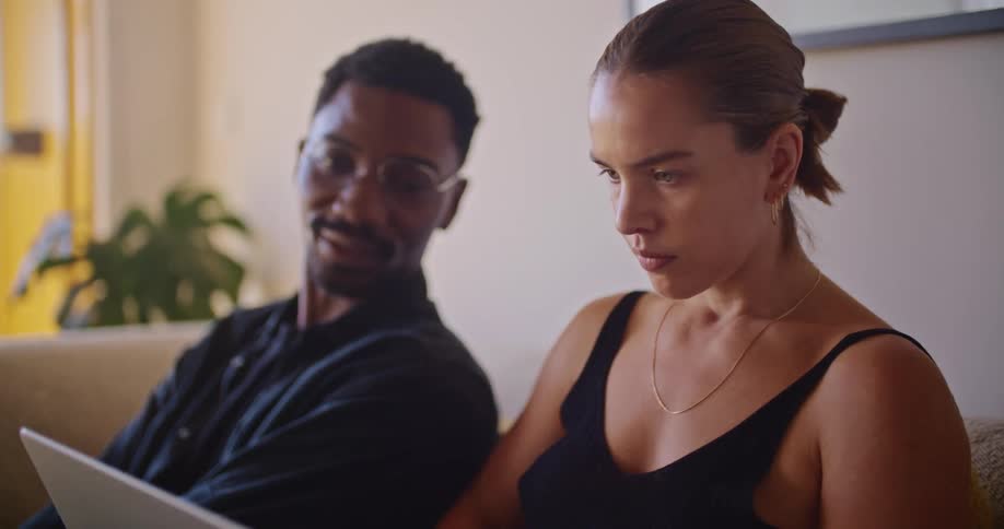 A man and woman look at a laptop