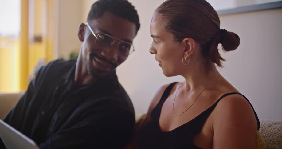 A man and woman talk and look at a laptop