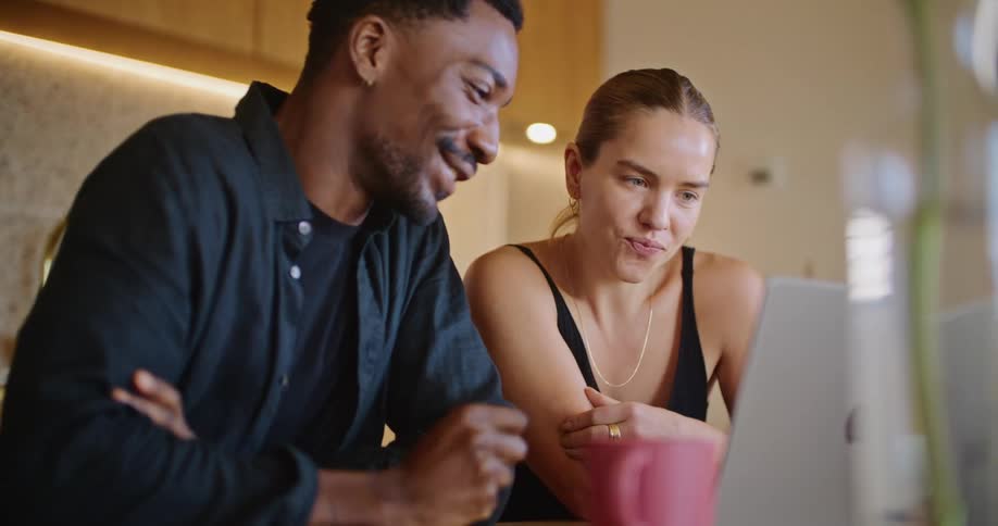 A man and woman talk and look at a laptop