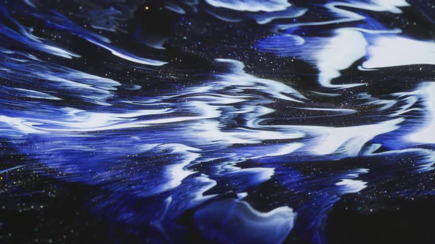 A formation of clouds moves in a dark sky with golden sparks and glitter