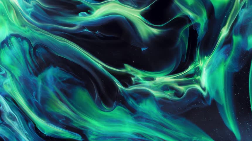 Glowing green and blue neon organic masses stretch as they move across the darkness
