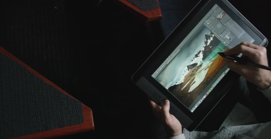 A man is editing a photograph on a tablet