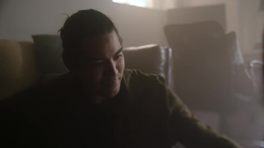 A man sitting on his living room floor across from another person
