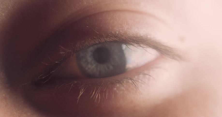 An extreme close up of a persons eye blinking slowly