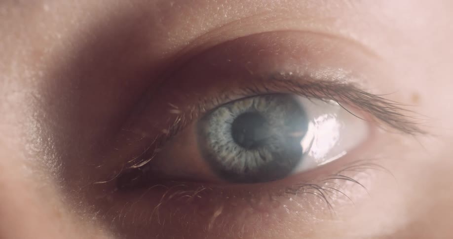 Light shines on a person eye as they move their eye around a little bit and move their eye lid