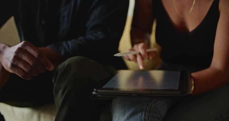 A man and woman look at a tablet