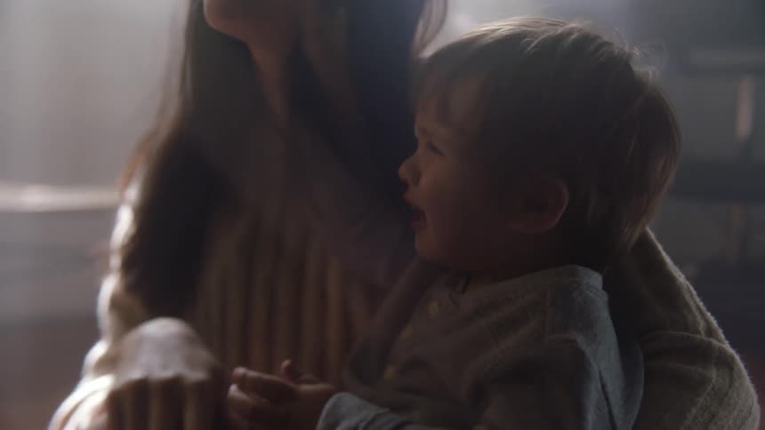 A mother holds her angry crying son