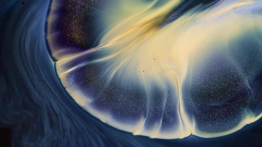 A rounded area of glowing yellow wisps pushes through the fiber outside of the orb and sparkling particles spill inside as it grows and spreads
