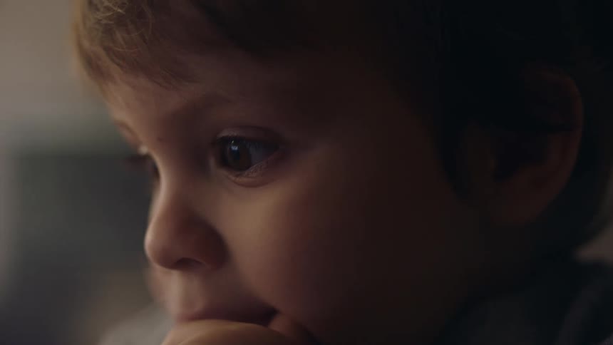 Closeup shot of a boys face while thinking about something and holding his hand at his mouth