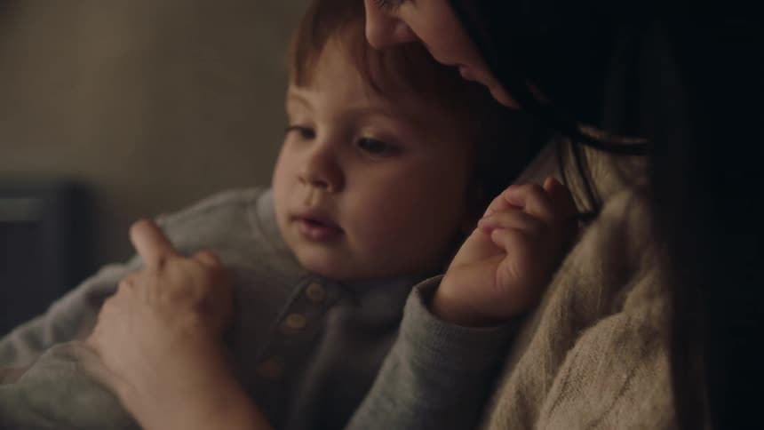 Mother comforting toddler sitting on her lap