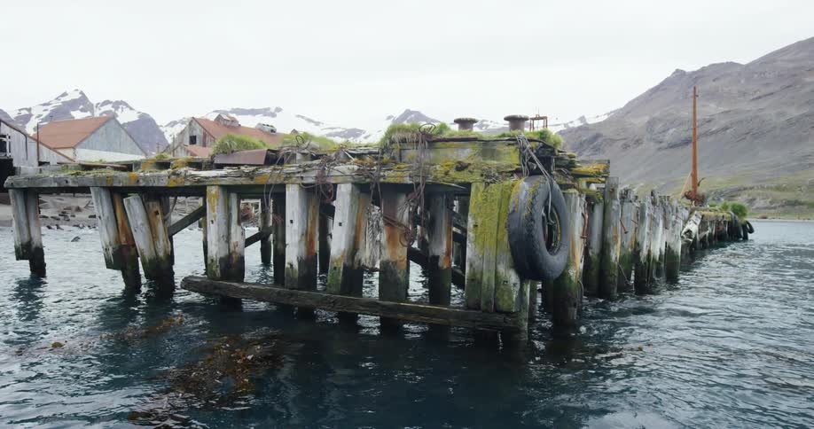 A tire is hanging off an old pier in a small village
