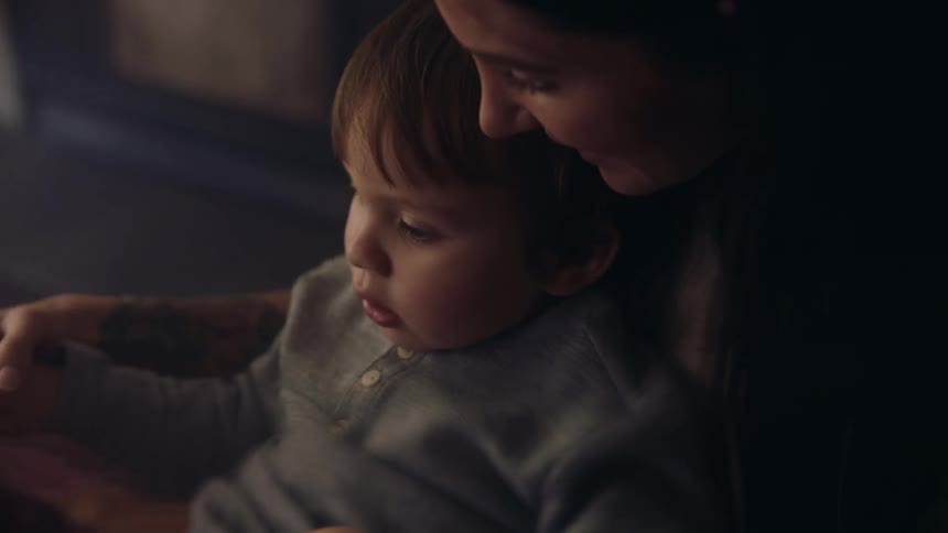 A mother is holding and talking to her son