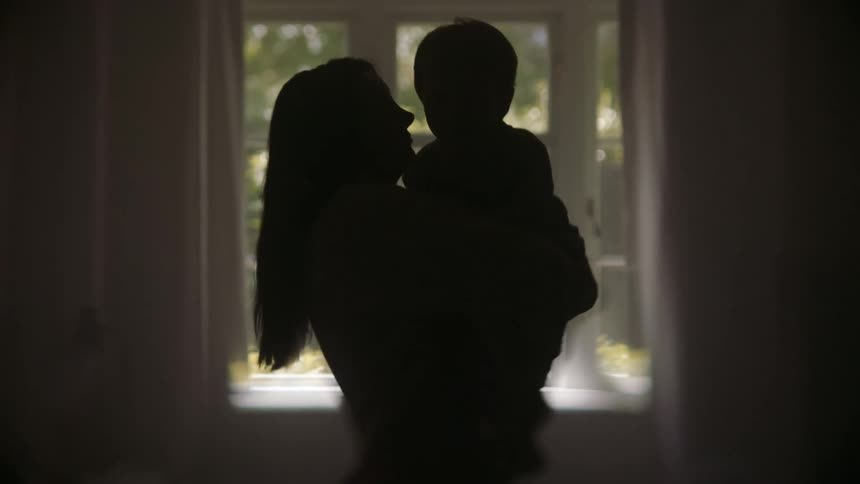 A mother is holding her son