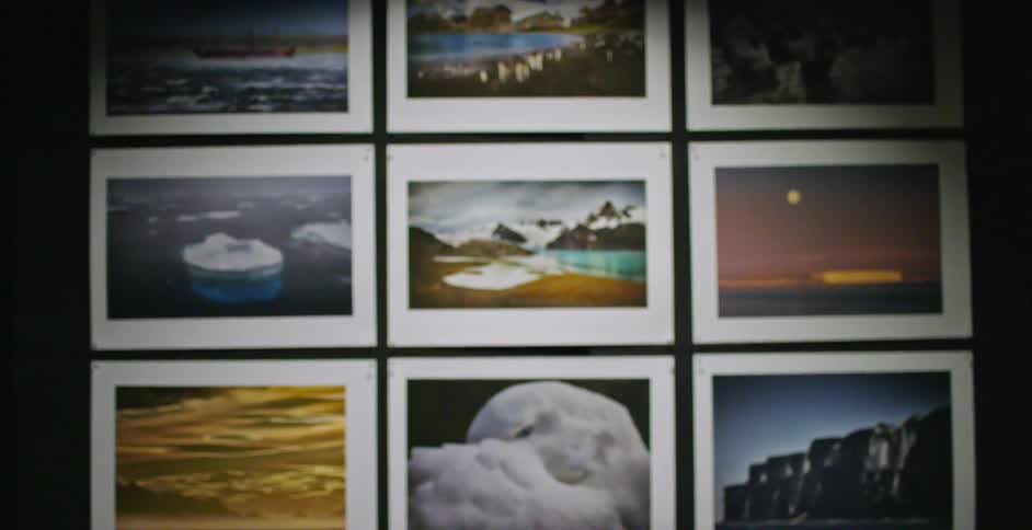 A man is looking at artwork on the wall before walking off