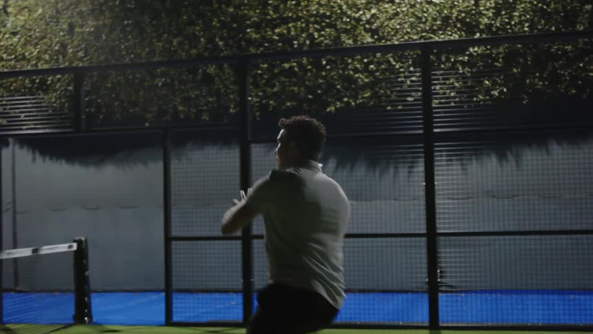 A young white man is outside playing tennis with someone