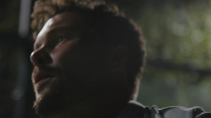 The view is of a young man that is outdoors at night time