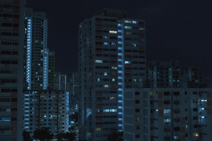 A time lapse view of tower buildings in a city skyline as their windows light up and turn off at night