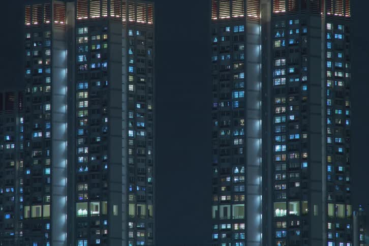 High rise condominiums with flashing lights turning on during night