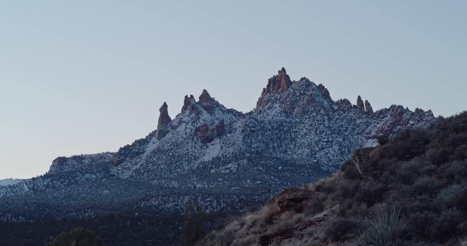 Rocky spires covered by snow are seen at dawn in the desert