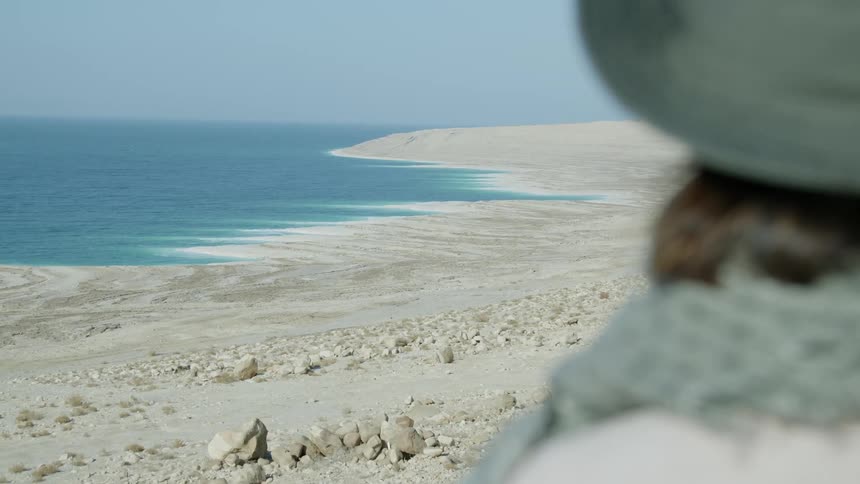 The view is of a person on the beach and looking at the ocean