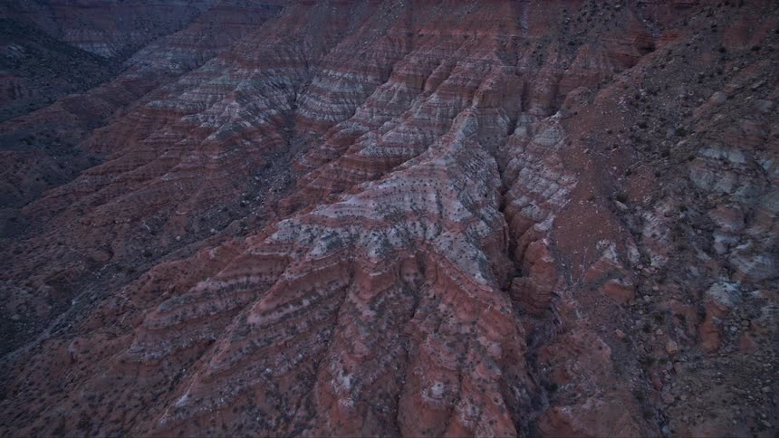 Aerial view of desert mesas and geological erosion at dusk