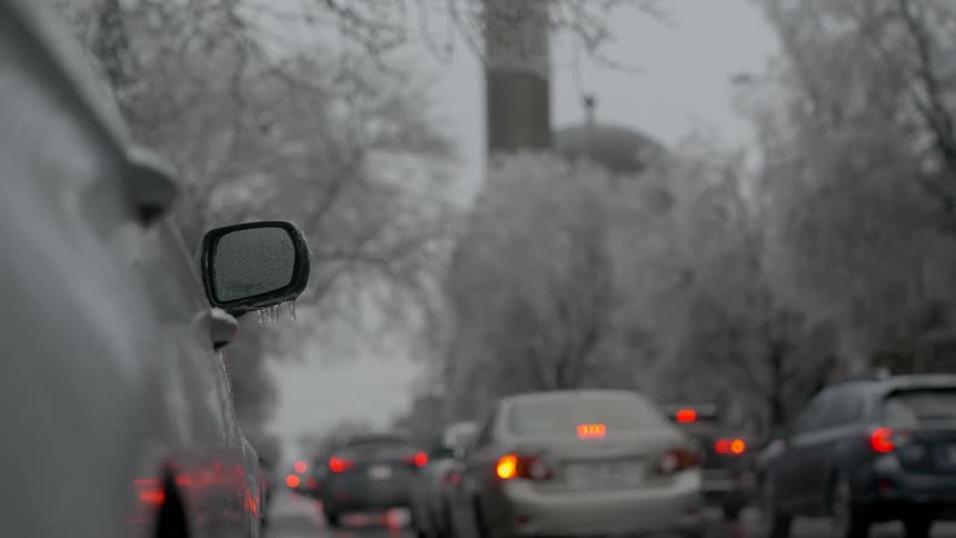 Cars are driving down the street outdoors in the day time