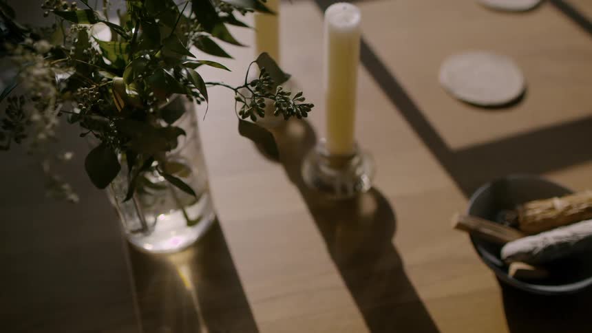 Candles and a vase are used as decoration on a table