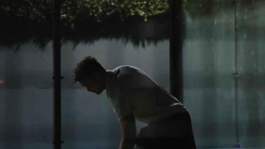 A young white man is playing tennis outdoors in the day time