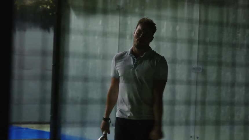 A young white man is playing tennis outdoors in the day time