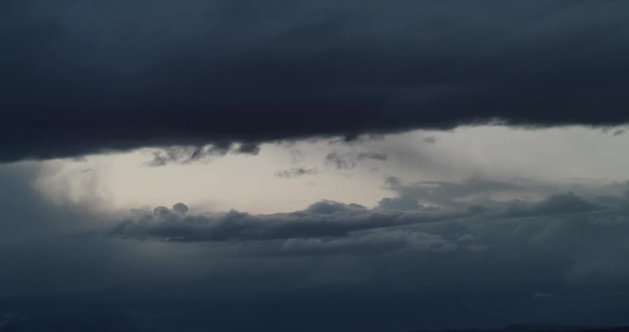 Ominous storm clouds move across the sky as darkness falls