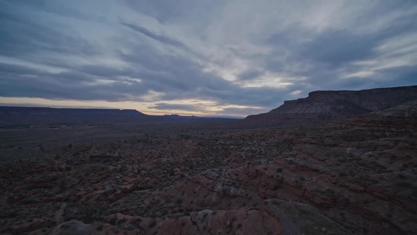 An aerial view of a desert canyon and mountains in Utah at dusk