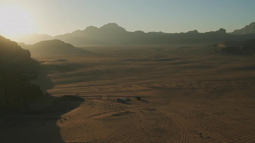 Aerial view of the desert next to the mountains at evening