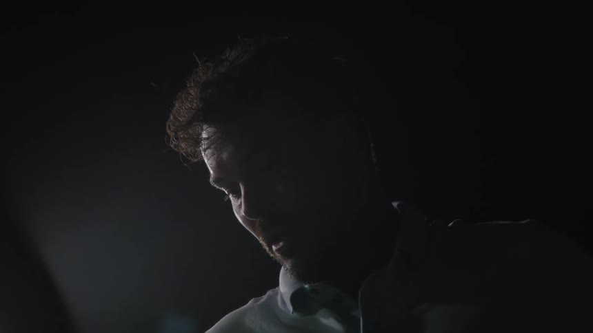 Close up of the face of an out of breath man talking on a cold night