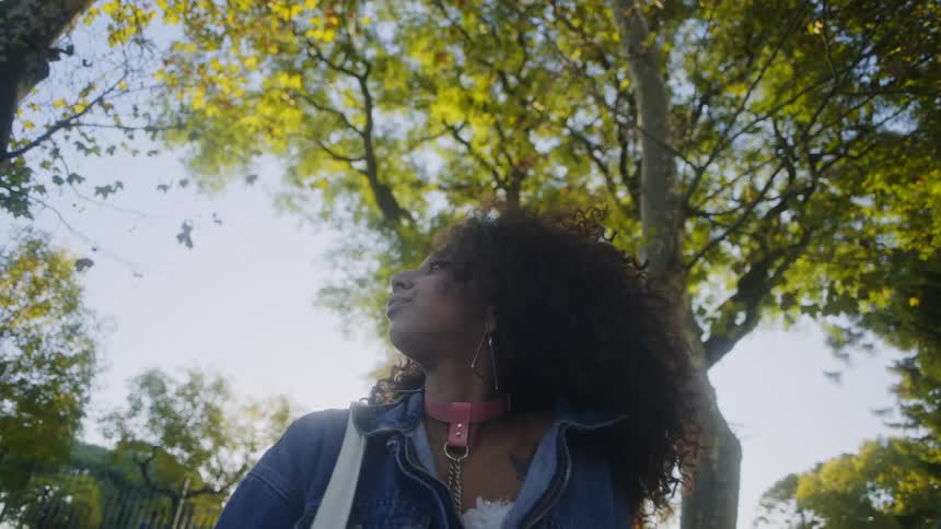 Close up of the face of a young attractive woman looking around under the trees at morning