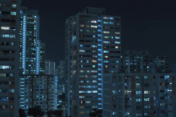 High rise condominiums with flashing lights turning on during night
