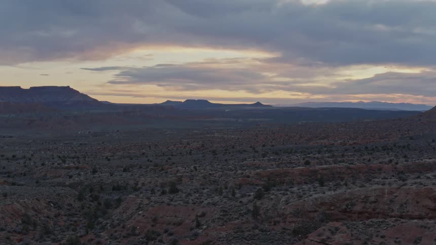 Aerial view of desert vegetation across layers of mountain ridges in the evening