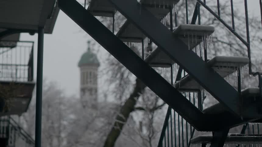 Close up of a staircase on the side of a building in the city freezing in winter at daytime