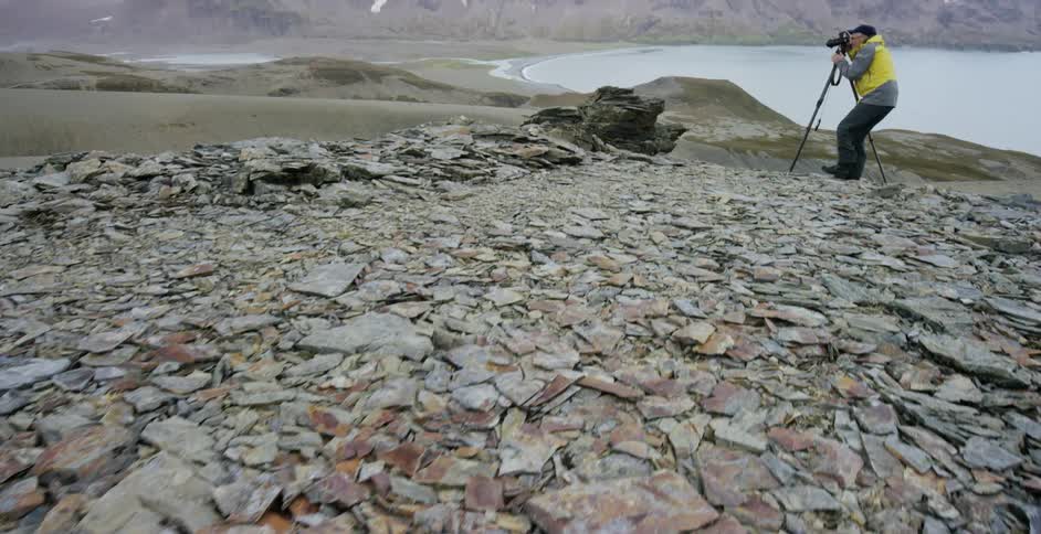 A man is taking photographs of a mountain range