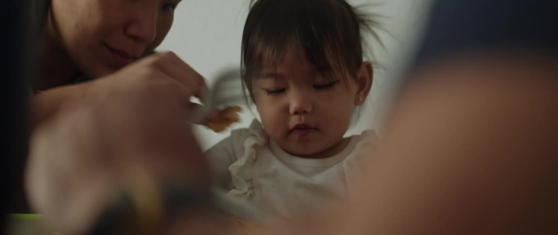 Parents feeding her daughter in the dining room at home