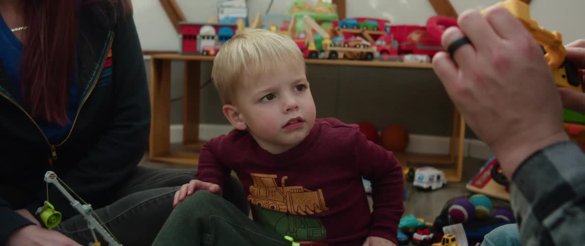 Father and son playing with toys on the floor of a room