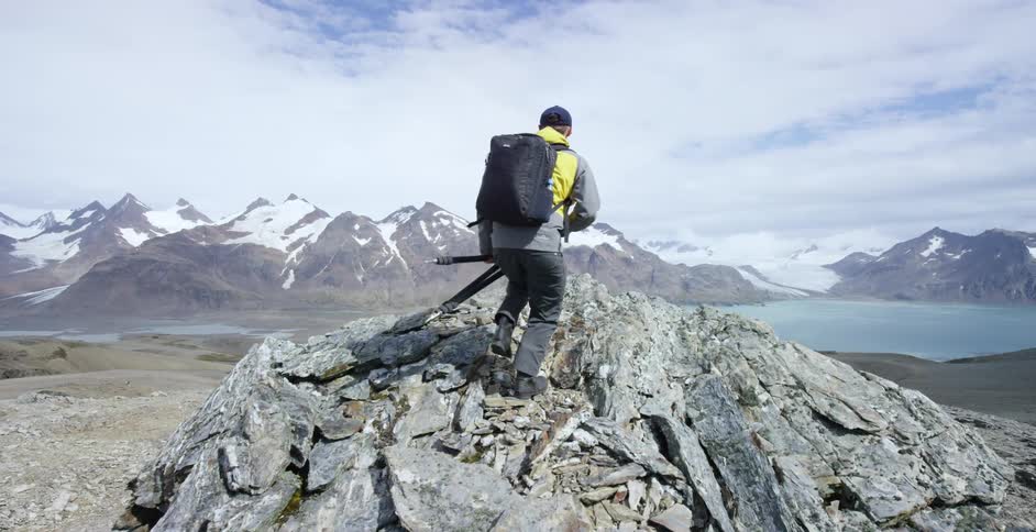 Man climbs up to the top of a rocky cliff