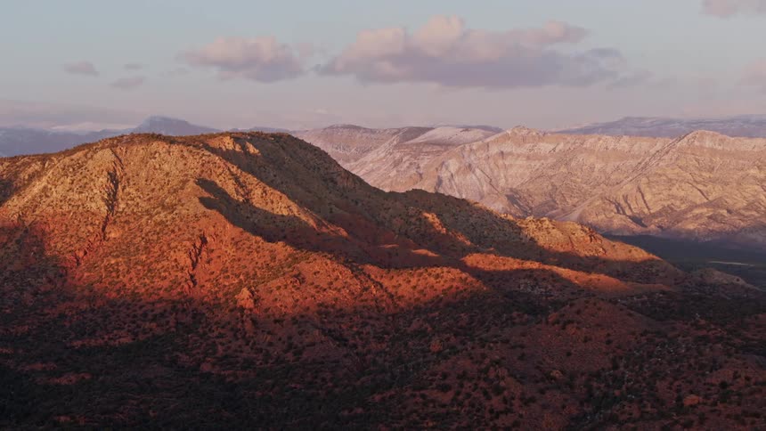 Red rock mountains seen in last golden light from an aerial perspective